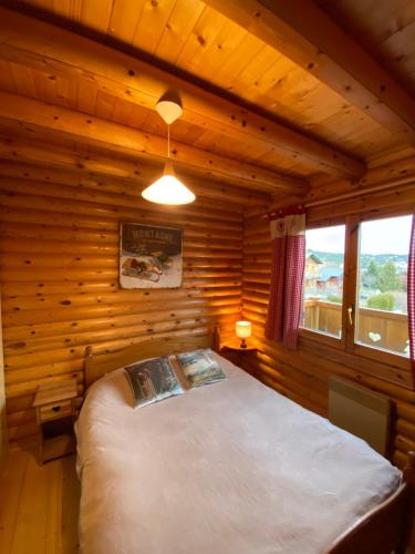 a bedroom with a bed in a log cabin at Chalet en rondins avec magnifique vue in Font-Romeu-Odeillo-Via