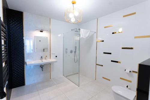 a bathroom with a glass shower and a sink at MODERNO hotel Garwolin 