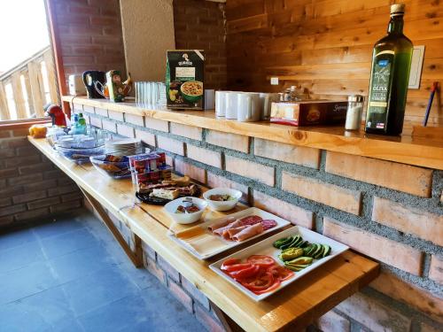 a counter with plates of food and a bottle of wine at Cabañas Santa Maria Huife in Pucón