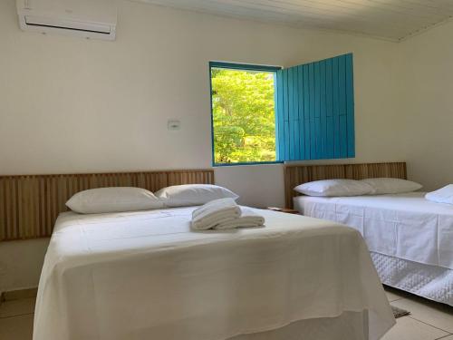 um quarto com duas camas com lençóis brancos e uma janela em Lostpoint Home em Monte Alto