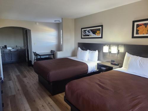Habitación de hotel con 2 camas y lavamanos en Quality Inn & Suites, en Dumas