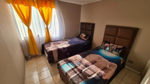 a bedroom with two beds and a window at Hermoso departamento a buen precio en excelente ubicación in Iquique