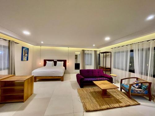 uma sala de estar com uma cama e um sofá em Le Kentia em Lomé