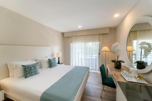 a hotel room with a large bed and a desk at TUl BLUE Xanthe - Ultra All Inclusive in Side