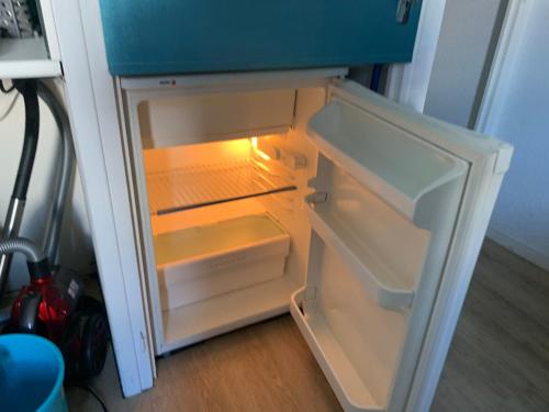 an empty refrigerator with its door open in a room at La Mongie Tourmalet, 2 a 4 couchages, pied de pistes, station de ski in Bagnères-de-Bigorre