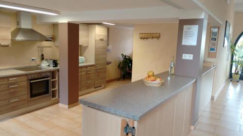 a kitchen with a counter with a bowl of fruit on it at Landgasthaus Oberbillig in Holsthum