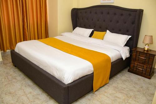 a bedroom with a large bed with a yellow blanket at Cozy 2 bedroom in Kitale-Fully Furnished at 360 Luxury in Kitale