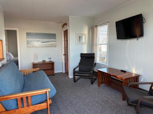 a living room with a blue couch and a chair at Moontide Motel, Apartments, and Cabins in Old Orchard Beach
