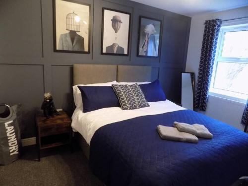 a bedroom with a blue and white bed with towels on it at 4 Bed Luxury Townhouse - Parking - Lincoln in Lincoln