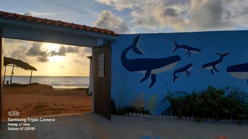 科魯里皮的住宿－Casa beira mar com piscina Coruripe Povoado Miai de cima，海滩上一座建筑的一面壁画