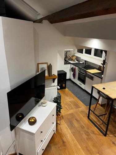 a large white kitchen with a large flat screen tv at Studio cosy in Brussels