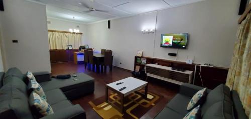 - un salon avec un canapé et une télévision dans l'établissement R.KAWIMBE FURNISHED APARTMENTS, à Lusaka