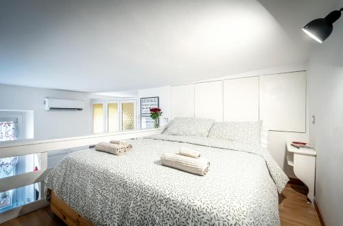 a white bedroom with a bed with two towels on it at Metro a 4 minuti Loft made in Italy with Free WiFi in Milan