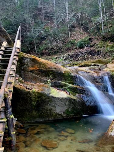 a bridge over a creek with a waterfall at "Глиняна хатинка" in Beloberëzka