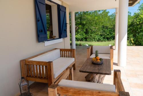 a patio with a table and chairs on a porch at Villa Mawali in Sainte-Anne