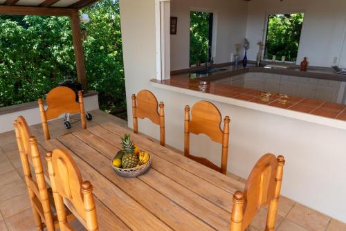 a table with two chairs and a bowl of fruit at Villa Mawali in Sainte-Anne