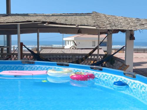 una piscina vacía con sombrilla e inflable en Villa CERRILLOS, en Camaná