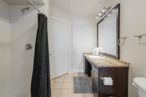 a bathroom with a sink and a mirror at Spacious 2br Corporate Suite, Parking, Pool Cs in Dallas