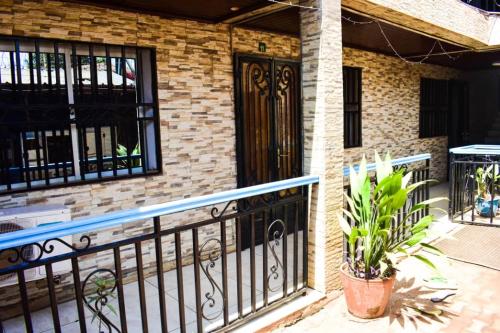 a porch with a black fence and a potted plant at Appartement/Studio meublé a Bangui in Bangui