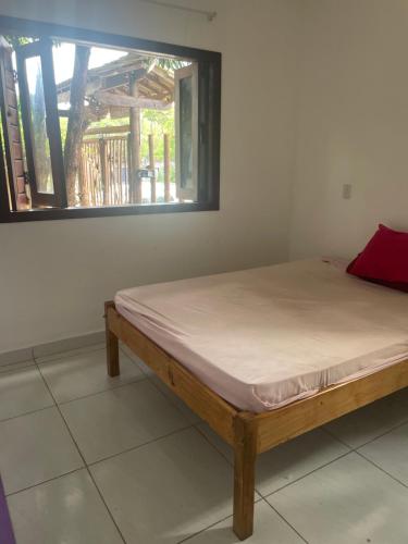 een bed in een kamer met een raam bij Apartamento em Pipa in Pipa