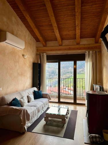 a living room with a couch and a large window at EL BALCÓN PANORÁMICO DE GREDOS in Mijares