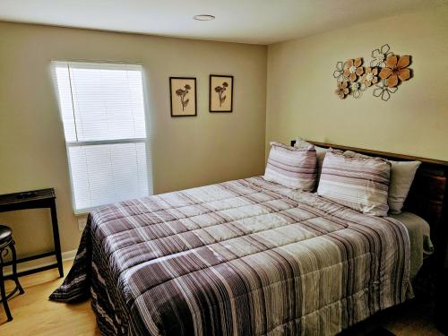 una camera da letto con un letto con una coperta a righe e una finestra di Da.Luxe Cottage Mtn Island Area on 1.56 Acres a Charlotte