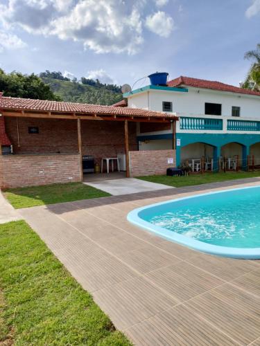 een huis met een zwembad naast een gebouw bij Recanto Betânia 