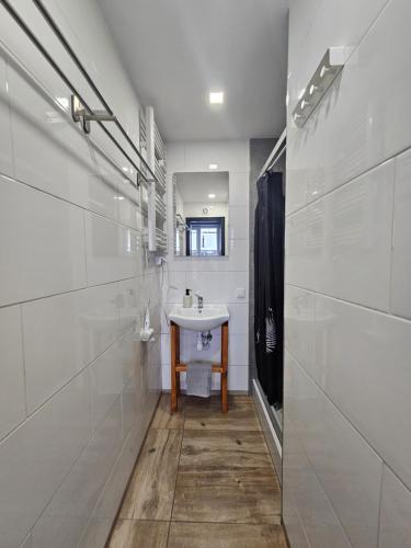 a white bathroom with a sink and a mirror at Północna Rooms in Łódź