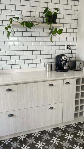 a white kitchen with a counter top with plants at CASA EN LA FELIZ - pet friendly in Mar del Plata