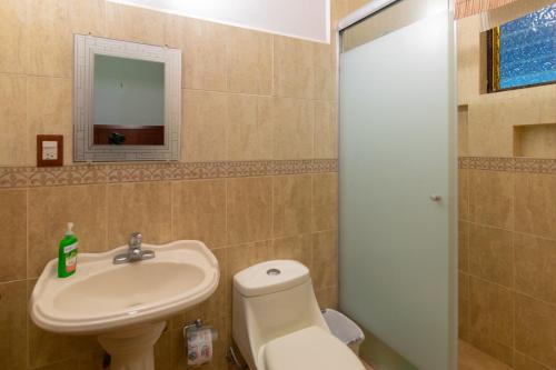y baño con lavabo, aseo y espejo. en Quinta Alondra casa campestre, en Los Sauces