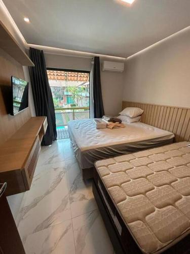 1 dormitorio con 2 camas y ventana en Casa Temporada Villagio Del Mare, en Salinópolis