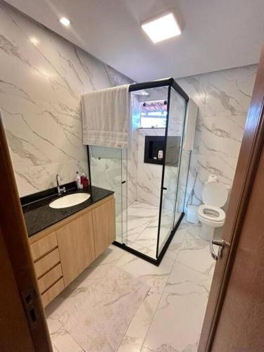 W łazience znajduje się prysznic, umywalka i toaleta. w obiekcie Casa Temporada Villagio Del Mare w mieście Salinópolis