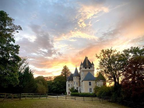 an old castle with a sunset in the background at Château de La Tour en Brenne in Rivarennes