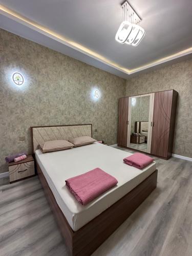 Sweet Apartment in Narimanov في باكو: غرفة نوم بسرير كبير ومرآة كبيرة