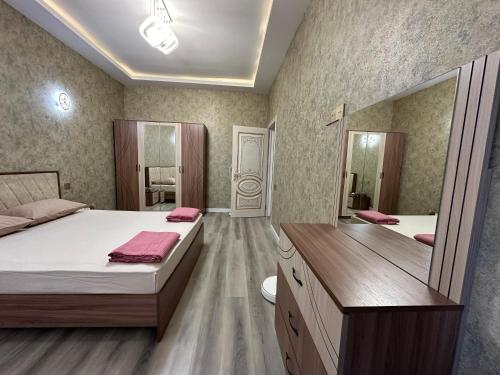 Sweet Apartment in Narimanov في باكو: غرفة نوم بسريرين ومرآة كبيرة