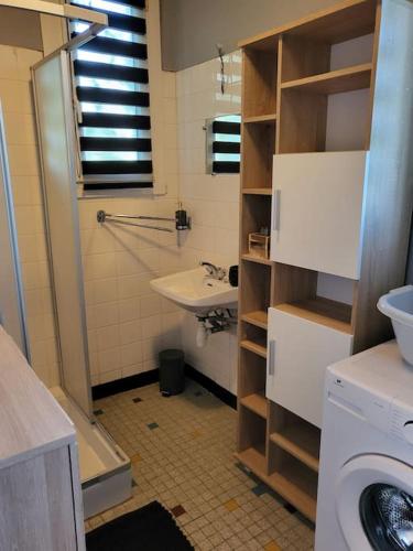 une salle de bain avec un lavabo et une machine à laver dans l'établissement Maison de campagne avec jardin près du Périgord, à Mansac