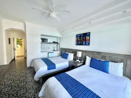 a hotel room with two beds and a ceiling fan at Cancun Plaza - Best Beach in Cancún