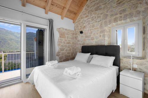 a bedroom with a bed and a large window at Villa Sulic - Heated Pool and Mountain View in Zagvozd