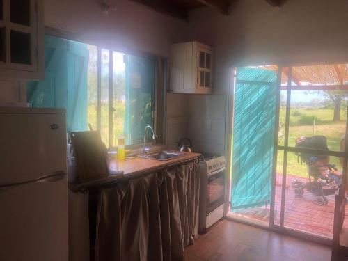 cocina con fregadero y nevera en La casita de Valizas, en Barra de Valizas