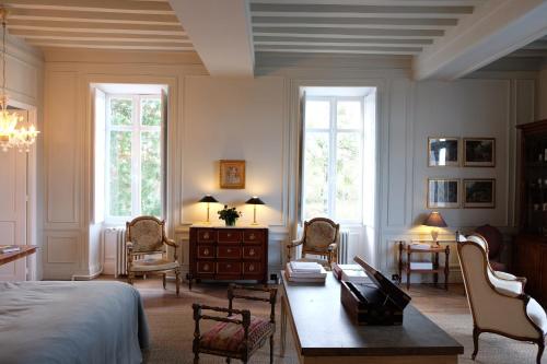 Rivarennes的住宿－Château de La Tour en Brenne，卧室配有一张床和一张桌子及椅子