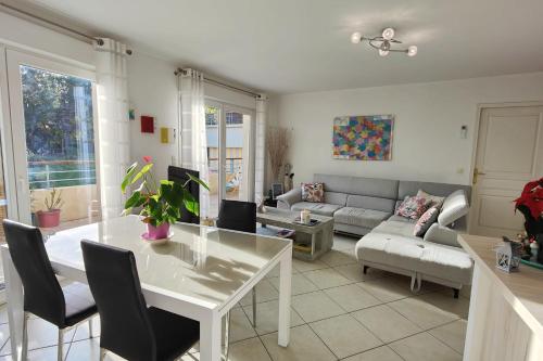 un salon avec une table blanche et un canapé dans l'établissement Spacious nest with terrace and shared pool, à Fréjus