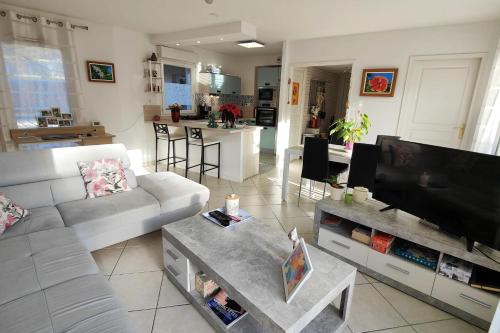 un salon avec un canapé blanc et une télévision dans l'établissement Spacious nest with terrace and shared pool, à Fréjus