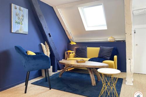 - un salon avec des murs bleus, un canapé jaune et une table dans l'établissement Le St-Laurent - Magnifique Triplex - Calme, à Caen