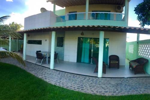 een huis met een balkon en een patio bij CASA NA PRAIA DO SACO-SE in Estância