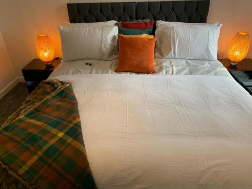 Stunning 2-Bed Apartment in Grays في ثوروك الغربية: سرير ابيض كبير فيه مصباحين ومخدتين