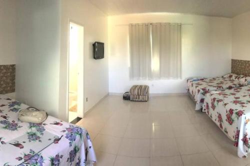 een hotelkamer met 2 bedden en een televisie bij CASA NA PRAIA DO SACO-SE in Estância