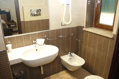 y baño con lavabo y aseo. en Villa Adriana Hotel, en Tívoli