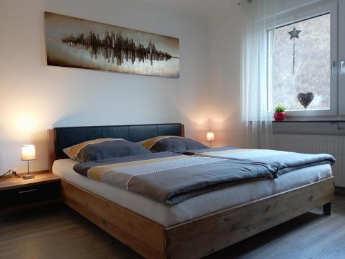 ein Bett in einem Schlafzimmer mit zwei Lampen und einem Fenster in der Unterkunft Talblick I in Cochem