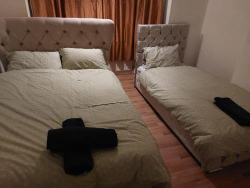 a bedroom with two beds with black crosses on them at Catford Homely Home in Hither Green
