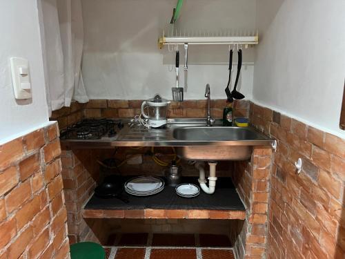 eine Küche mit Spüle und Ziegelwand in der Unterkunft Apartaestudios norte de barranquilla in Barranquilla
